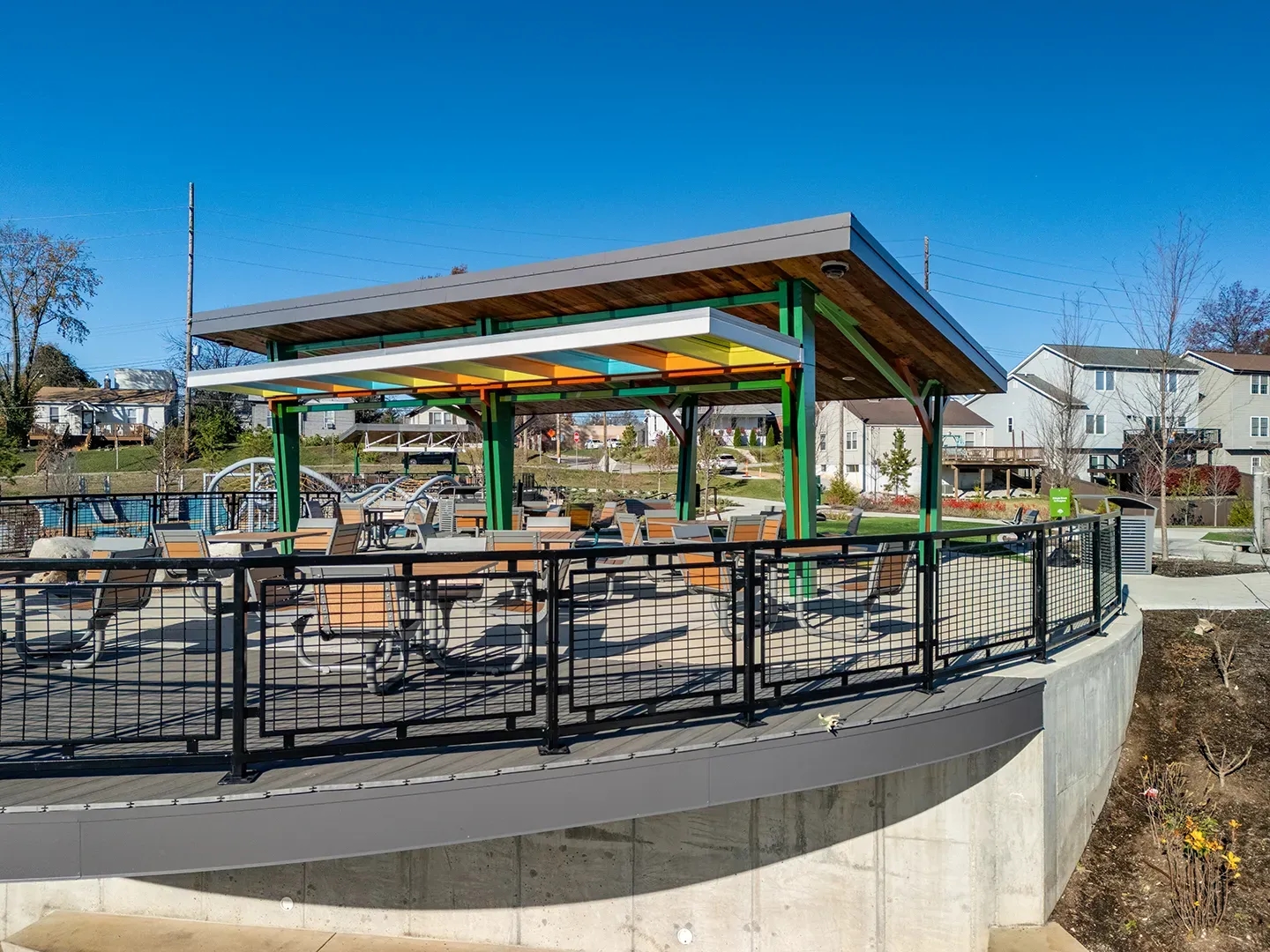 Aerial view of the Brentwood Pavilion at Destination Playground in Brentwood Park, featuring colorful light panels, shaded seating for 44, and nearby playground.